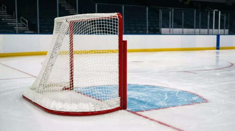 Nahaufnahme eines NHL-Eishockey-Tors mit weißem Netz und rotem Torrahmen auf der Eisfläche